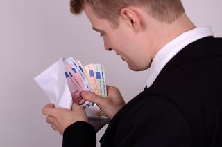 Foto: Mann mit Geldumschlag