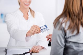 Foto: Patientin und Arzthelferin mit Versicherungskarte 